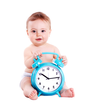 Baby boy holding the big blue alarm clock