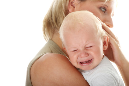 Mother holding her crying baby isolated